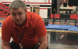 DataServ employee setting up technology in school gym for robotics