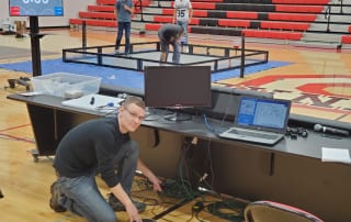 DataServ employee setting up technology in school gym